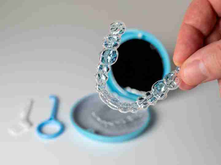 Hand holding a clear aligner tray