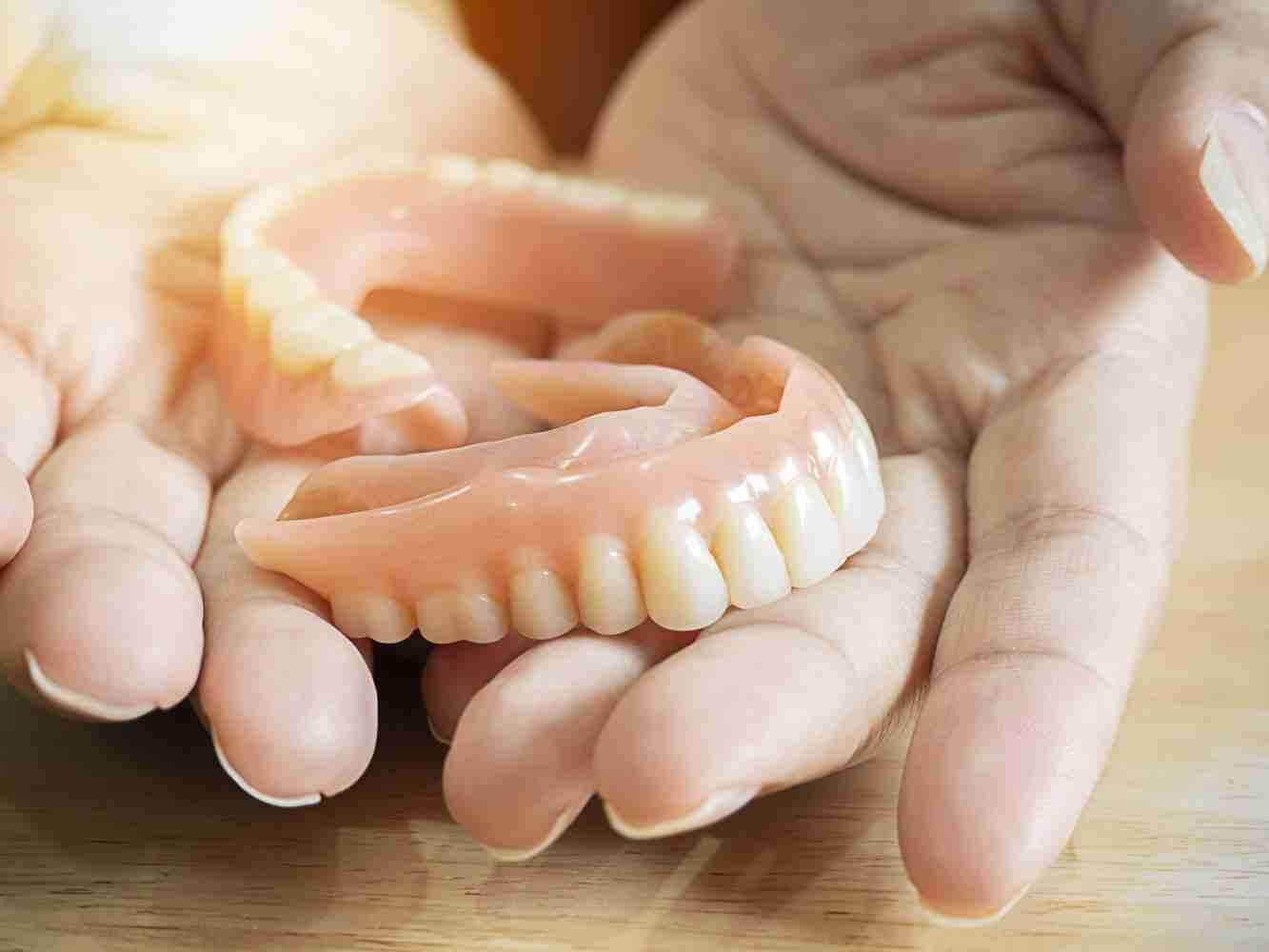 Hands holding a flexible partial denture