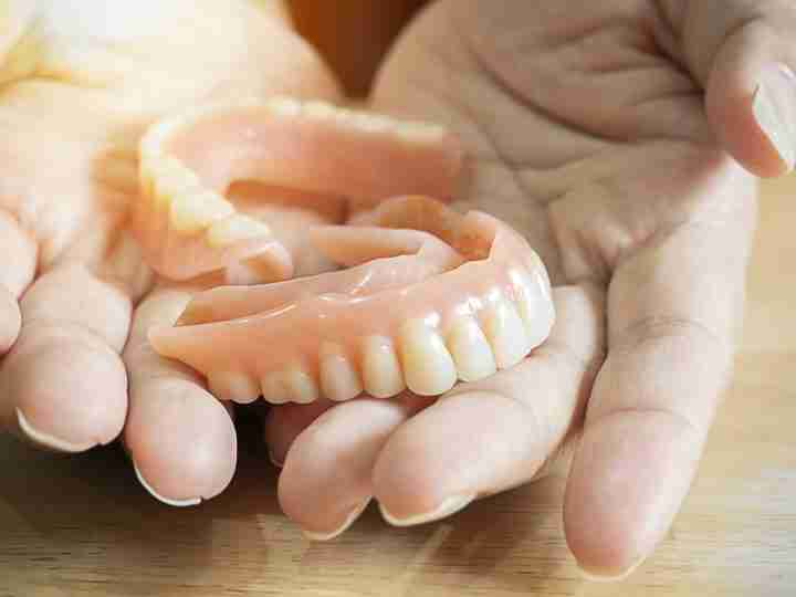 Hands holding a flexible partial denture