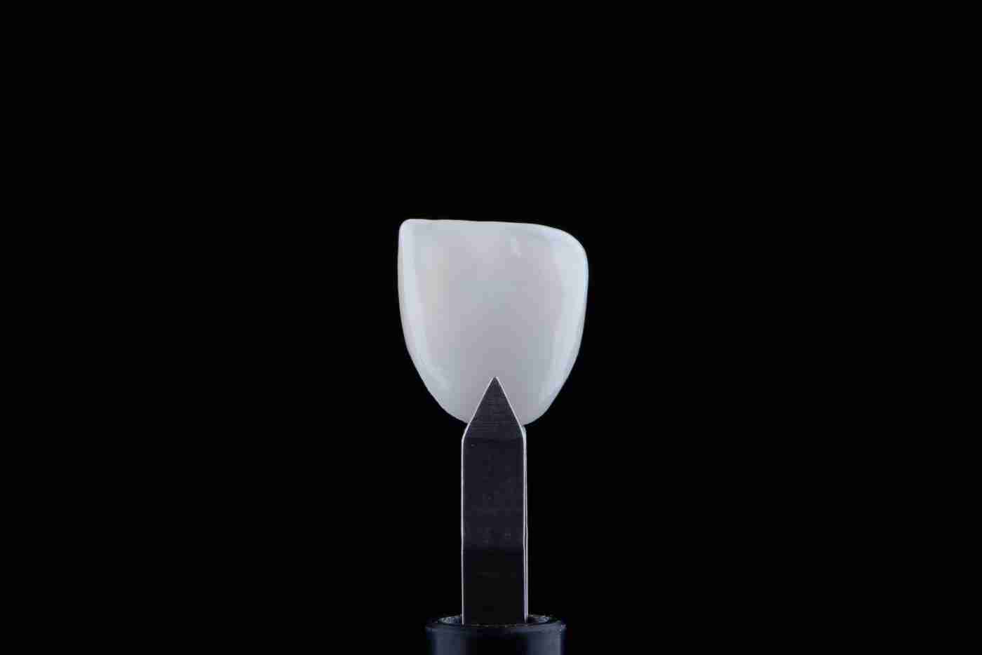 Ultra-thin porcelain veneer held with tweezers