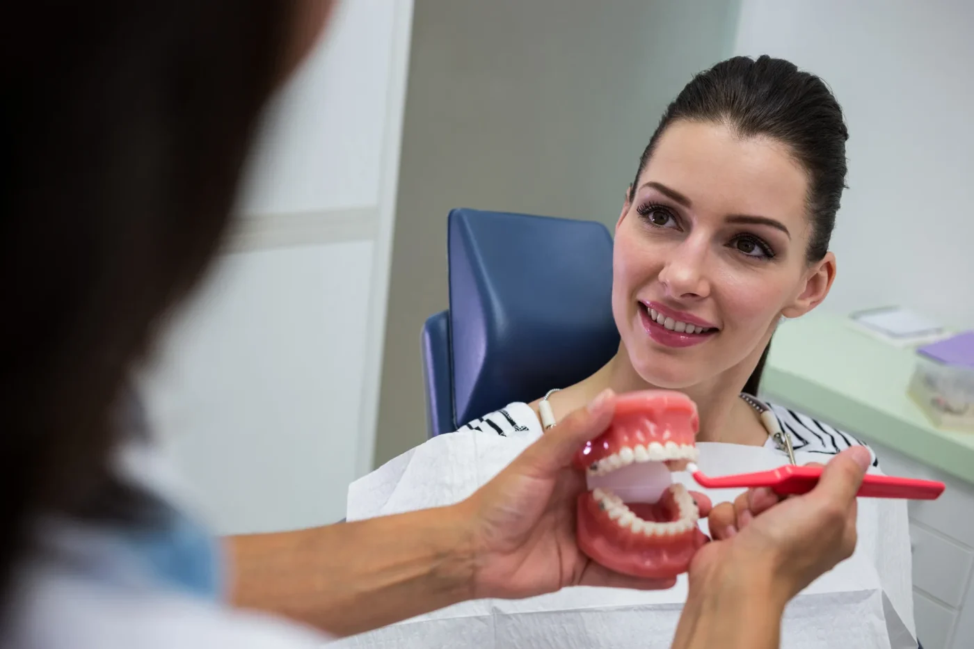 Dentist explaining dental implants on a model to a patient